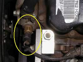 Located by the upper radiator hose on the engine.
